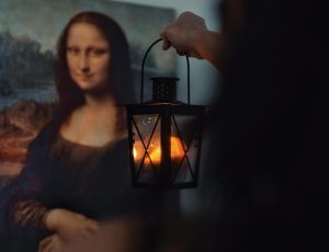 person holding lantern to the Mona lisa
