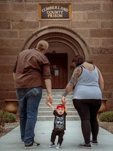 man, woman and child walking