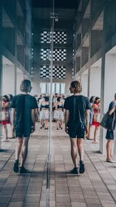 man walking beside mirror wall building