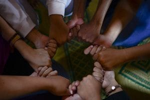 people in a group holding hands
