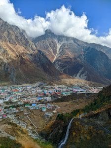 A town nestled in the mountains with clouds.