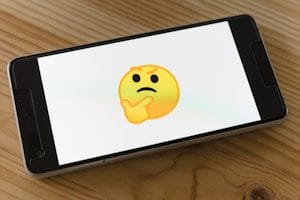 smartphone turned on displaying yellow emoji