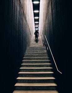 man in black pants going up stairs