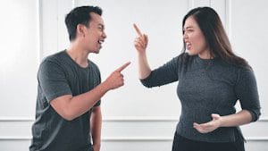 man in gray crew neck long sleeve shirt arguing with woman in grey crew neck shirt