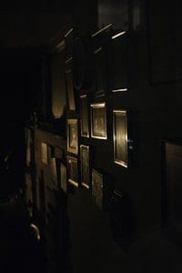 a dark room with a bunch of framed pictures on the wall