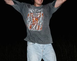 a man in a gray T shirt is holding his arms up